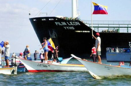 Opposers of Venezuelan President Hugo Chavez wave Venezuelan flags in support of the general strike at the oil tanker Pilin Leon (back), anchored in Lake Maracaibo, Venezeula, 13 December, 2002, some 500 km (310 miles) west of Caracas. As Venezuela’s volatile conflict led to a US call for early elections, Chavez raised the ante 13 December, threatening to import staff to replace strikers who have paralyzed the vital oil sector.  AFP PHOTO (Photo by AFP) (Photo by STR/AFP via Getty Images)